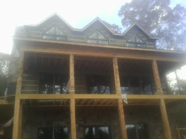 Dormers and porch framing on a large log home under construction — Roof Coating work by our crew in Kamas