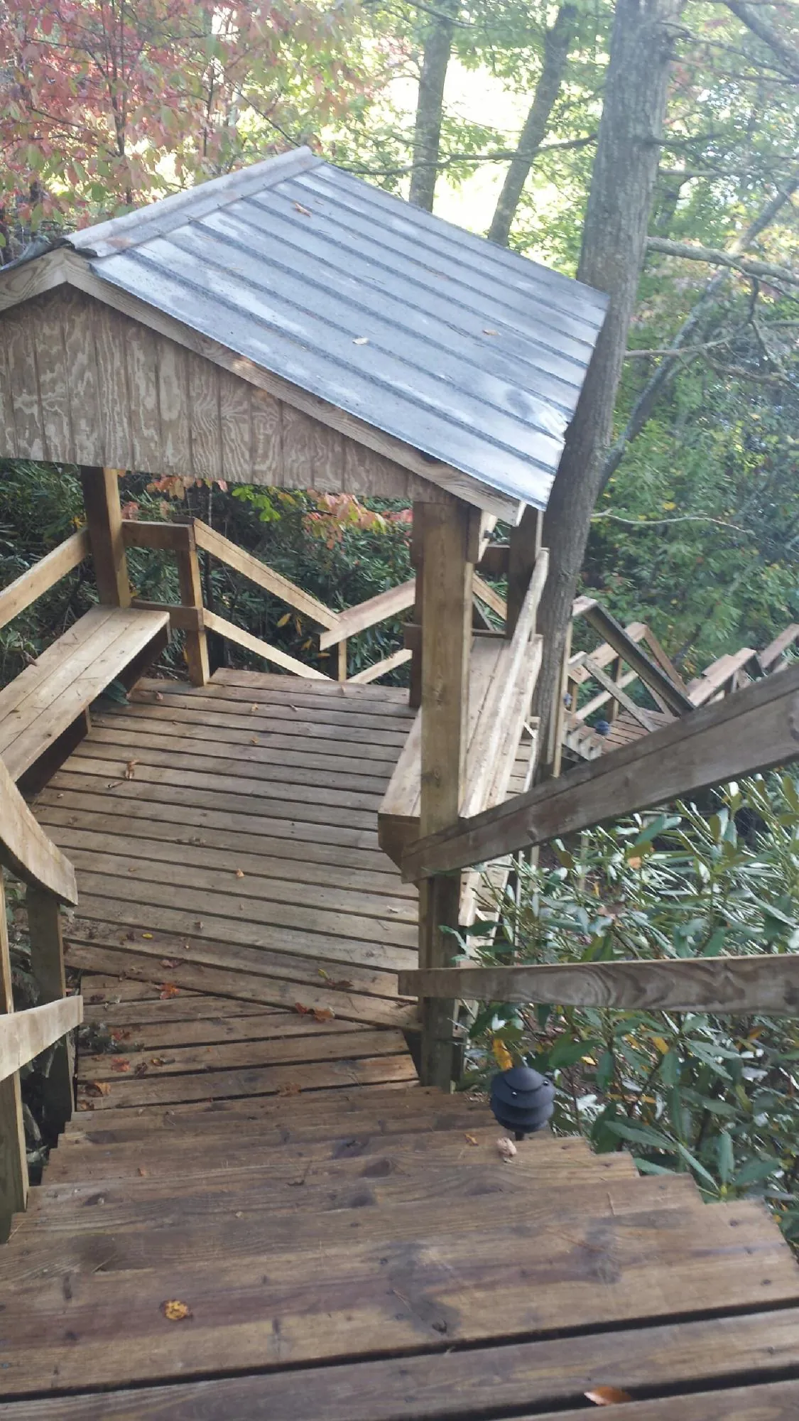 Metal roofed shelter over wooden steps on a wooded walkway — Skylight Repair & Installation work by our crew in Kamas