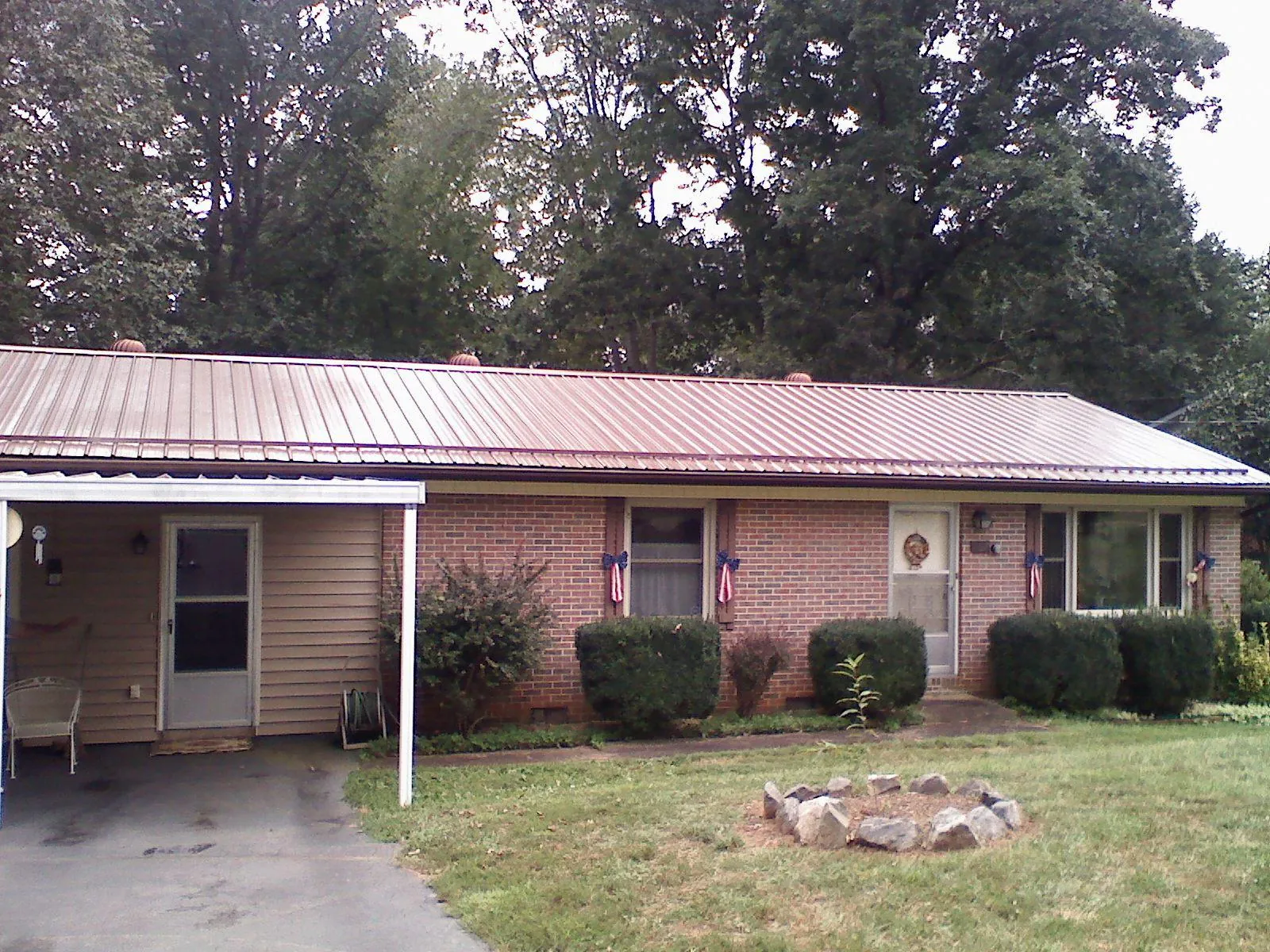 Bronze metal roof and carport on a brick ranch home — Roof Repair work by our crew in Kamas